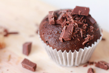 Chocolate cupcake homemade with chocolate pieces on a cutting board.