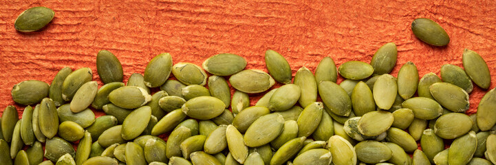 raw pumpkin seed against textured paper