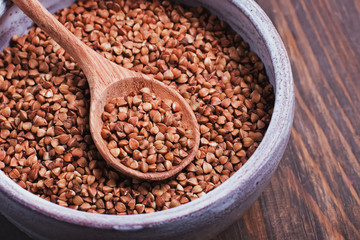 A wooden spoon of buckwheat close-up.