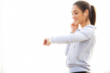 Fitness. Beautiful woman drinking water and listen to music after running