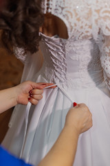 Obraz na płótnie Canvas Beautiful happy bride knotted dress. Wedding day.