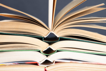 Fototapeta premium A simple composition of hardback books, raw books. Open books. Stacking books without inscriptions, empty spine. Back to school. Open book