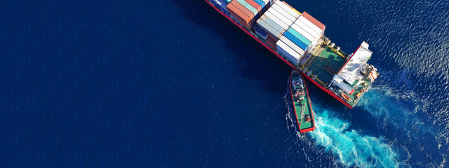 Aerial top down ultra wide photo of Container cargo Ship carrying load in truck-size colourful...