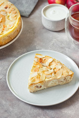 Baked cottage cheese crepes cake with almond and sour cream. Traditional Maslenitsa (Shrovetide) meal on gray background.