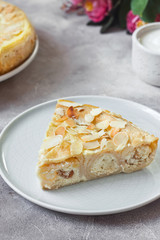 Baked cottage cheese crepes cake with almond and sour cream. Traditional Maslenitsa (Shrovetide) meal on gray background.