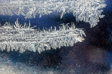 Frosty natural pattern on winter window, ornamental frost on the glass.