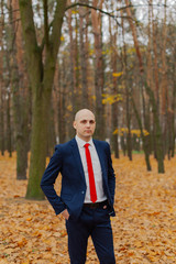 Handsome stylish man in a jacket in the autumn in the forest.