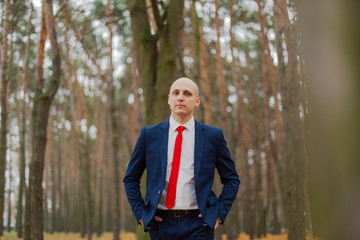 Handsome stylish man in a jacket in the autumn in the forest.