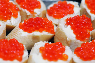 sandwiches with butter and red caviar as a macro background