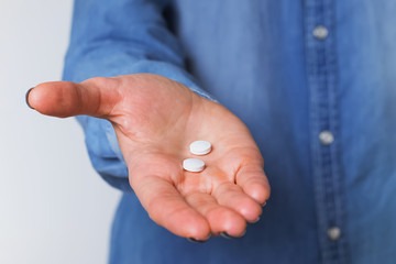 Woman's hand holding two white pills