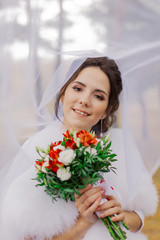 Happy bride under the veil. Portrait of a bride on a wedding day.