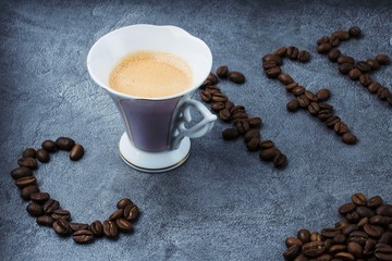 cup of coffee and beans on a gray marble background