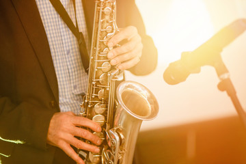 Obraz premium Jazz man musician playing saxophone with sun light