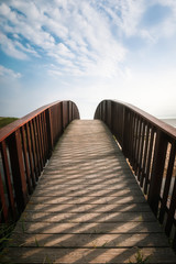 Fototapeta premium Bridge going up toward sky. Walkway on Sylt island, at North sea