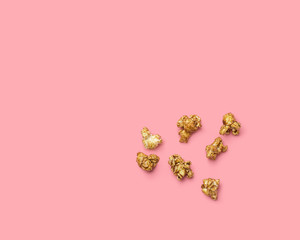 popcorn on a pink background, scattered popcorn. fried corn grains