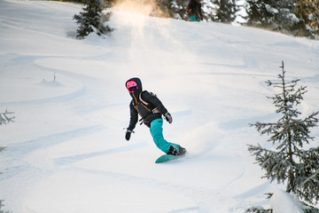 Woman sliding from mountain on a professional snowboard