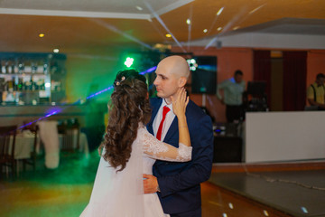 Happy newlyweds dance on the dance floor the first dance.
