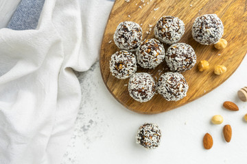 Coconut and nuts balls on a wooden board top view