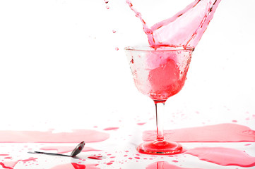 Red alcohol cocktail drink splash on white background .