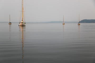 Sailboats at anchor on a hazy, smokey day during wildfires near Puget Sound