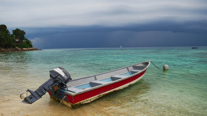 Old boat on the Beach of Perhentian Islands with a great thunderstorm / dark clouds in Malaysia