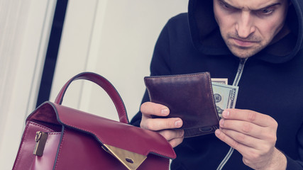 Pilferer with women wallet, man stole a woman's money and bag,  close up, toned, 16:9