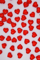Beautiful festive background for Valentine's Day. Red small hearts are scattered randomly on a white background.