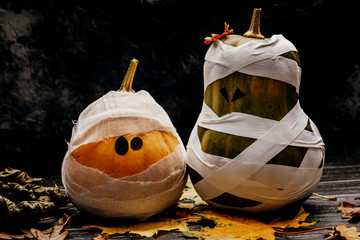 Zombie pumpkins in bandages, on a dark background. The concept of Halloween