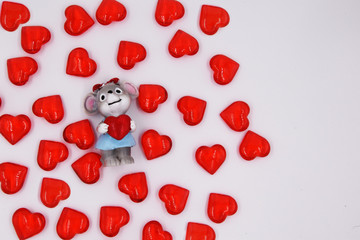 A mouse in love with a red heart in its paws, and many red hearts fly around.