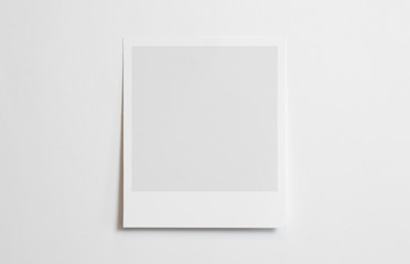 Blank polaroid photo frame with soft shadows tape isolated on white paper background as template for graphic designers presentations, portfolios etc.