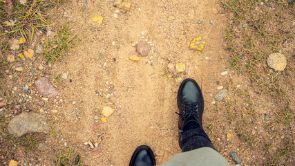 Girl goes on a sandy road, women's feet, top view, 16:9