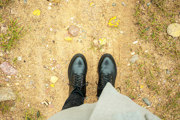 Woman standing on a sandy road, women's feet, top view