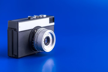 Old rangefinder vintage camera on blue background