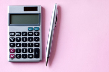 calculator and pen isolated on pink background