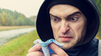 Sick man blew his nose, blocked nose, autumn flu, close up, toned, 16:9