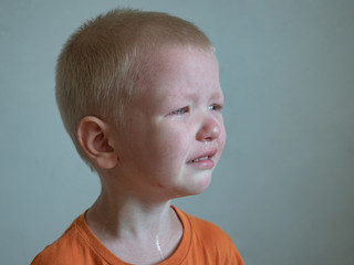 Blonde boy cries with tears. Upset child. Violence in family over children. Concept of bullying, depressive stress or frustration. Kid close up view. Pure authentic emotion. Copy space for text