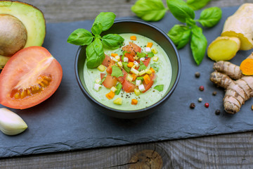 schmackhafte Avocadocreme mit Ingwer, Tomate und Kurkuma im schwarzen Schüsselchen in Nahansicht