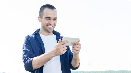 Handsome man uses smartphone, portrait, toned, 16:9