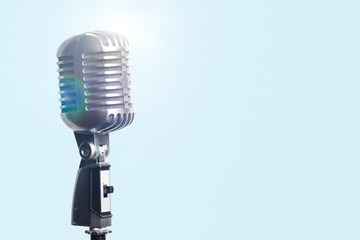 Retro style microphone on light blue background