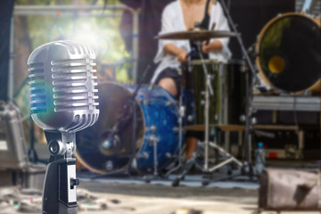 Retro microphone over the musician playing the guitar on band background with spot light, musical...