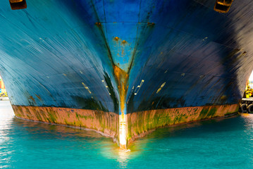 View of very large container ship bow part. Metal is damaged and rusty.