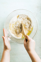 mixing dough for chocolate cake in a bowl. female hands and a kitchen whisk. recipe step by step
