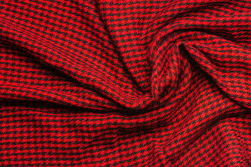 Wool crumpled cloth in a small black cage on a red background