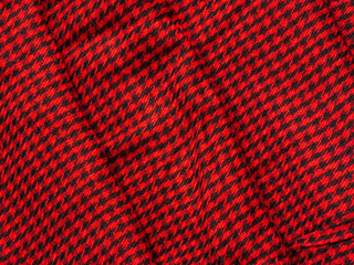 Wool cloth in a small black cage on a red background laid neat layers
