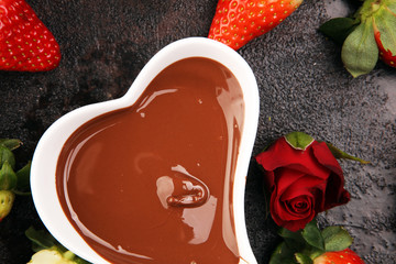 Valentine Chocolate fondue melted with fresh strawberries and dark and white chocolate. Red roses...