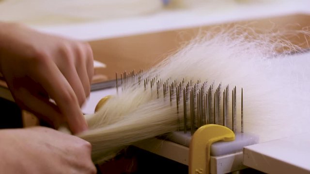 Hair combing when creating a wig. Factory wig production process