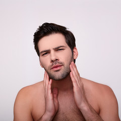 Fototapeta premium Brutal unshaven guy touches his stubble