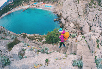 A woman descends the steps from the top of the mountain.