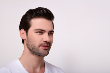 Fototapeta premium Portrait of a smiling handsome man in a white T-shirt.