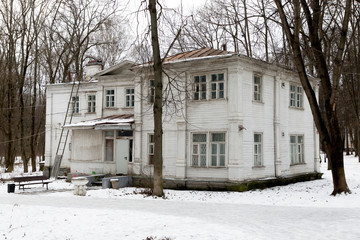 Wooden Russian estate, an old house of 2 floors, in winter, an abandoned building